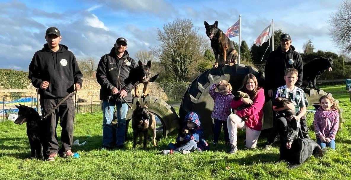 Handlers, dogs and family gathered at the training equipment on site at Woodborough